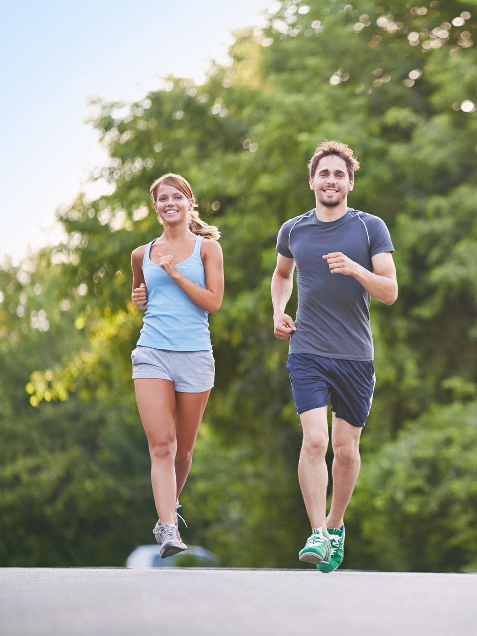 A man and a woman are jogging on a road.