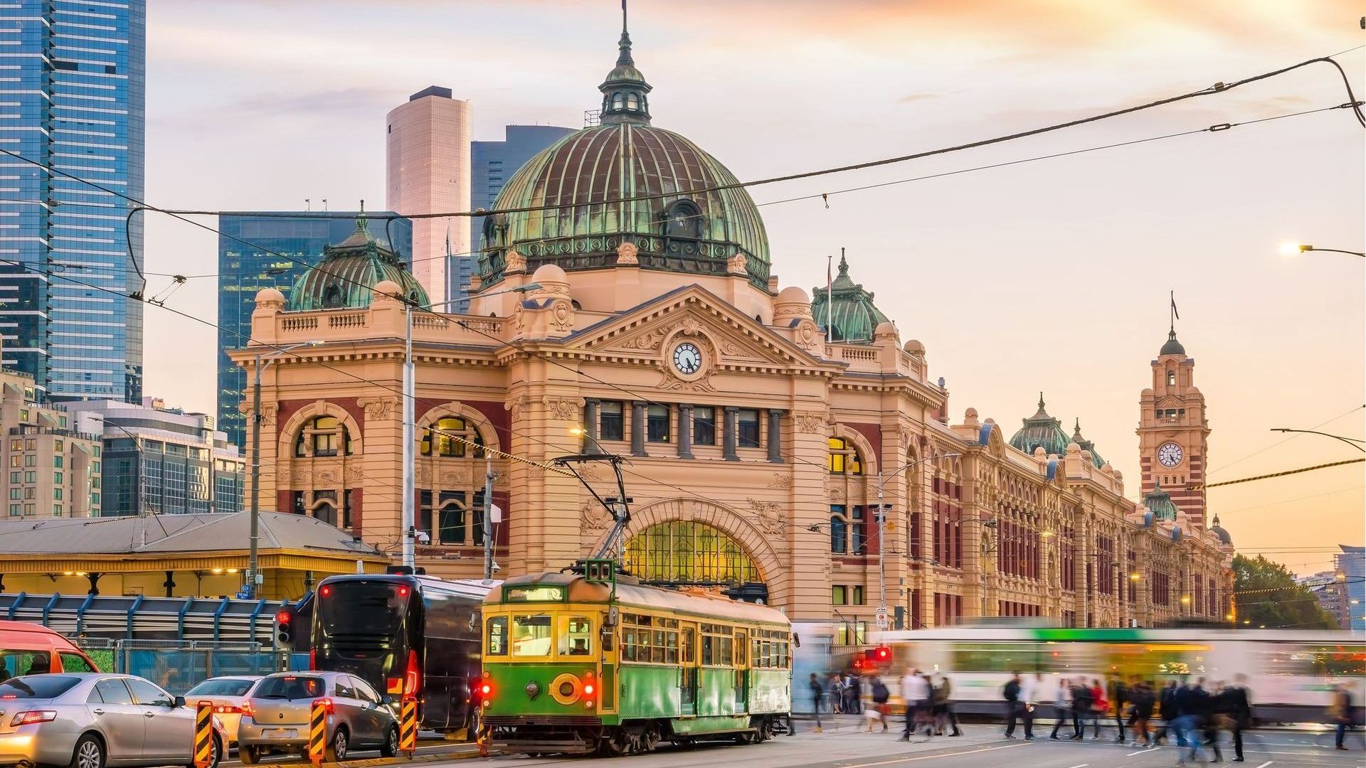 A trolley is parked in front of a large building in a city.