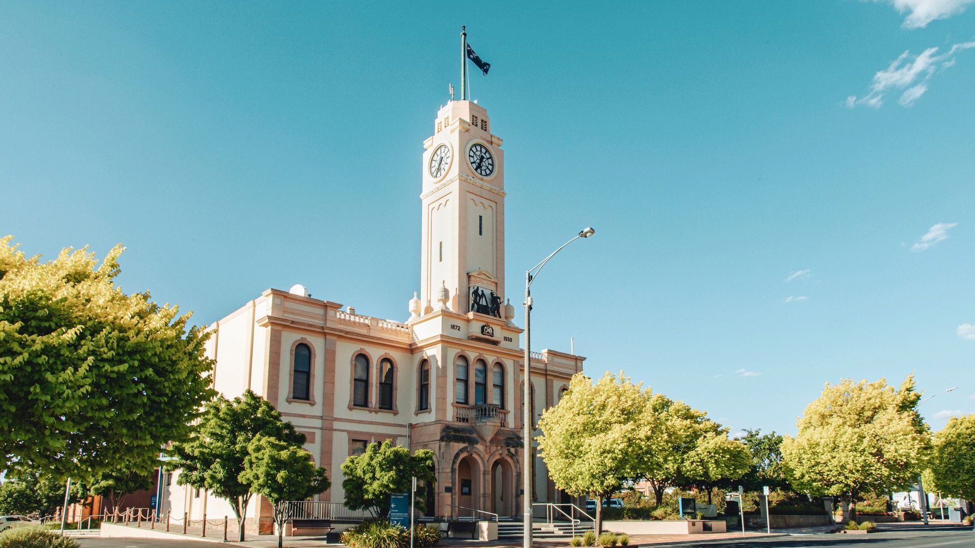 A large building with a clock tower and a flag on top of it.