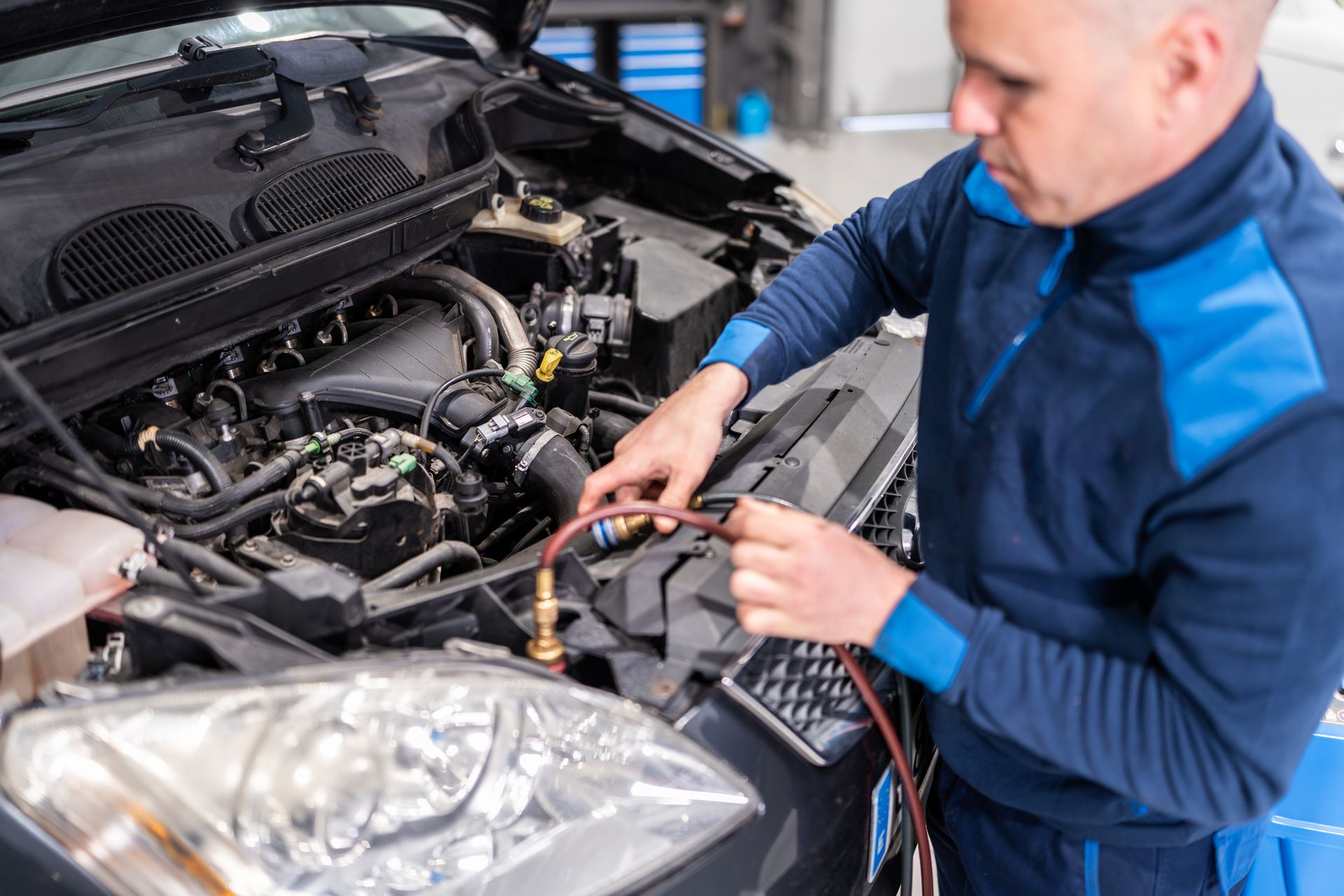 A mechanic examining engine oil in a vehicle, highlighting essential vehicle repair practices.