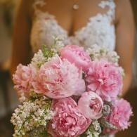 Bride holding a bouquet of pink peonies and baby's breath