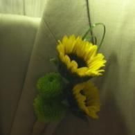 Small bouquet of yellow sunflowers and green flowers tied with a ribbon