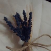 Small bundle of dried purple flowers tied with beige twine on a light background