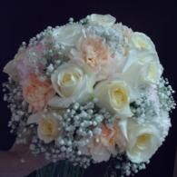 White and pale pink rose bouquet with baby's breath on a dark background