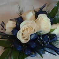 Bouquet of white roses with dark blue accents and greenery