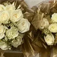 Two bouquets of white roses wrapped in gold-brown paper