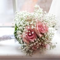 Pink rose bouquet with baby's breath on a white surface