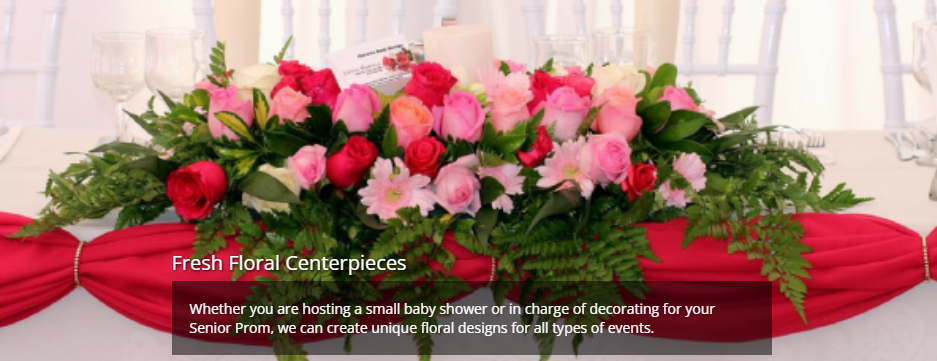 Pink and red flower arrangement on a red-draped table with a “Fresh Floral Centerpieces” banner