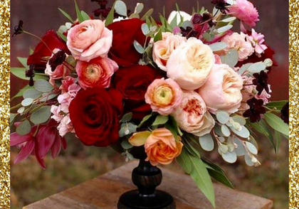 Pink, cream, and red roses arranged in a floral bouquet on a black vase