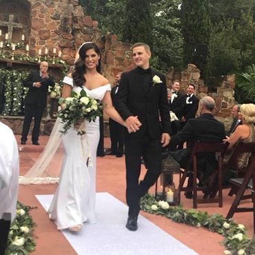 Bride and groom walking down an outdoor aisle at a wedding ceremony