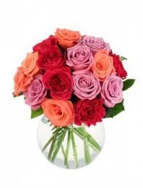 Bouquet of pink, red, and orange roses in a clear glass vase with ribbon ties