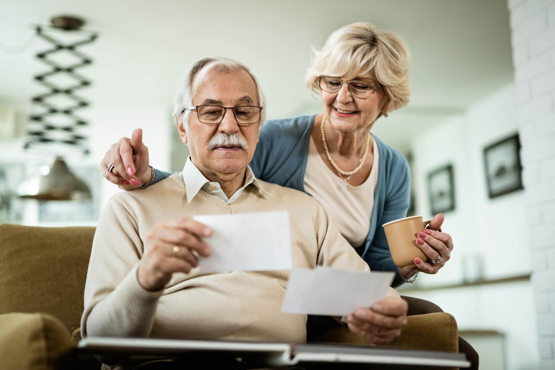 Una pareja de ancianos está leyendo documentos juntos en casa