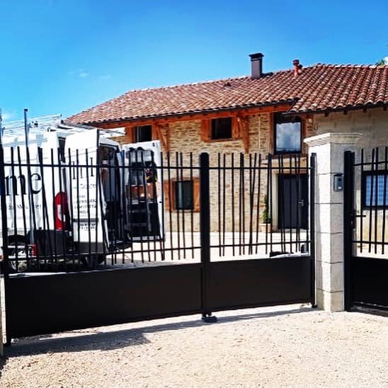 Portail deux battants asymétriques motorisés installé par TRIHOME Menuiseries à Coligny