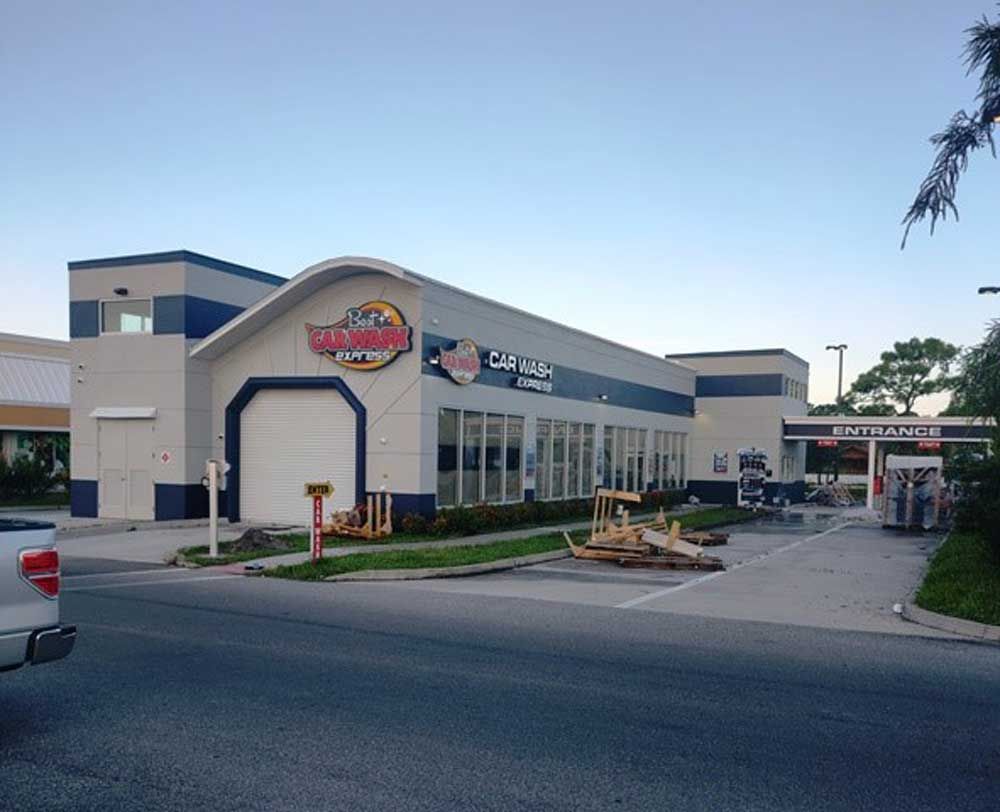 Exterior of a Wingstop restaurant at dusk, with a parking lot and drive-thru lane visible.