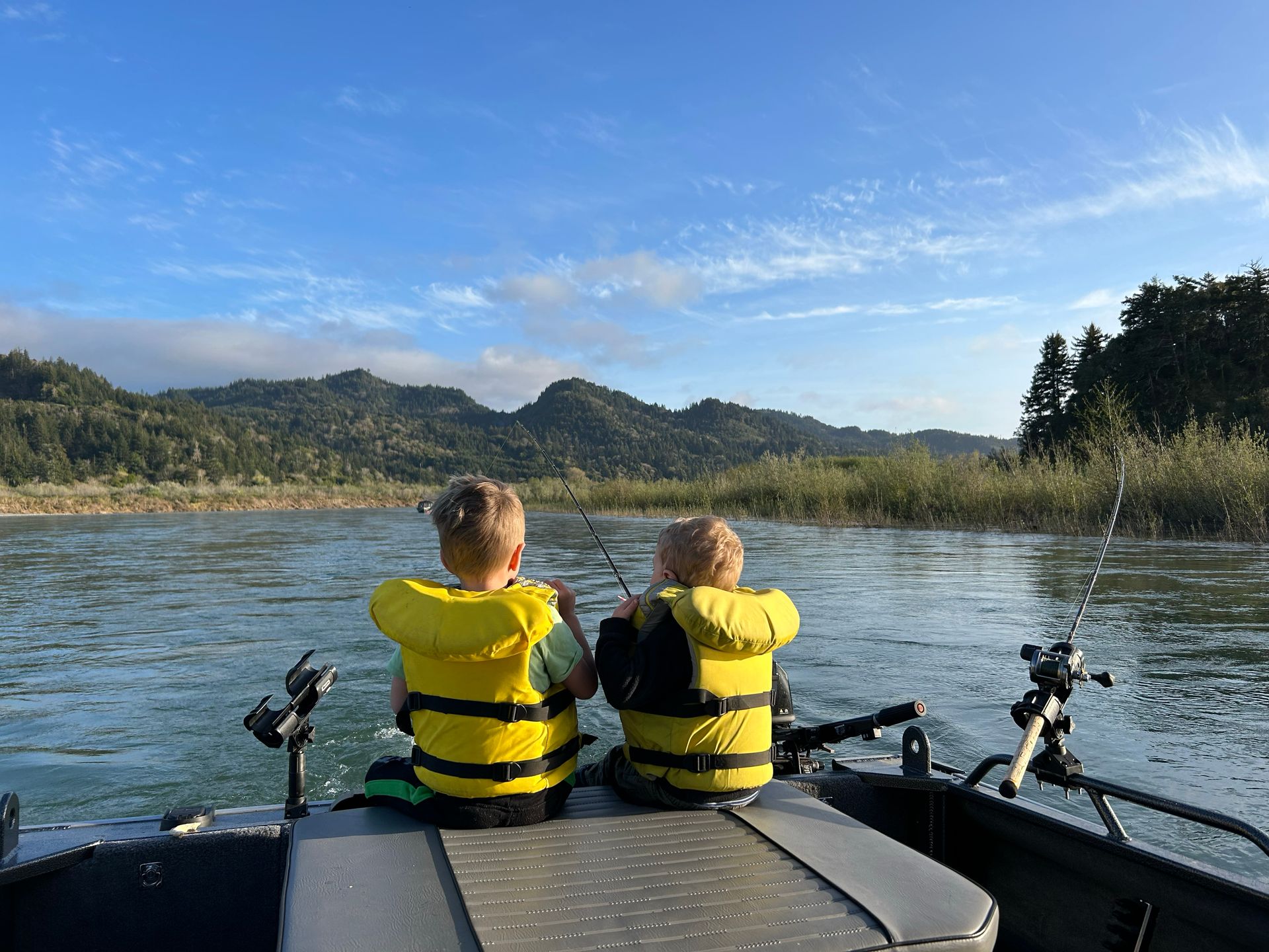 Two Young Boys Are Fishing in A Boat on A River