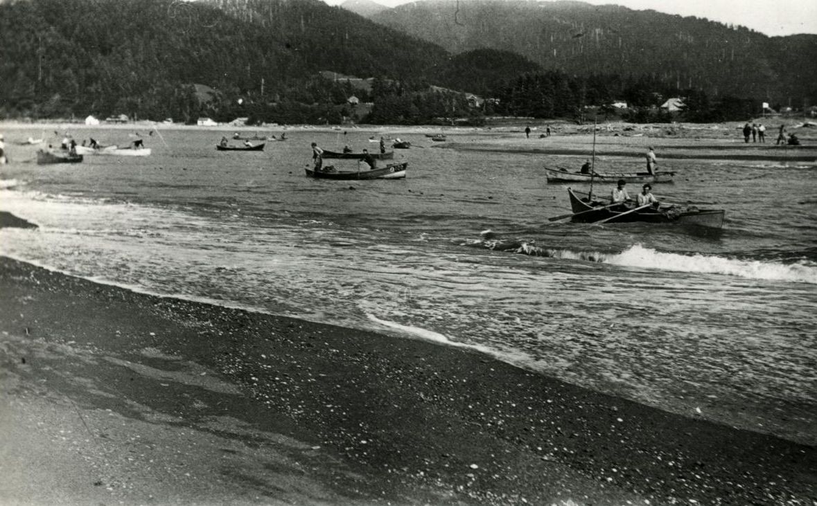 A Black and White Photo of A Beach with Boats in the Water
