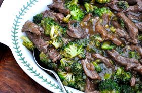 Platter of beef strips and broccoli in a glossy brown sauce on a white plate