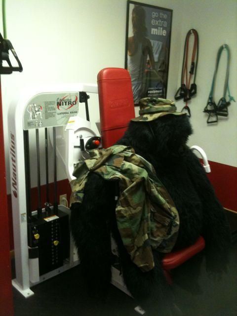 Red workout machine with camo jacket draped over it in a gym-like room