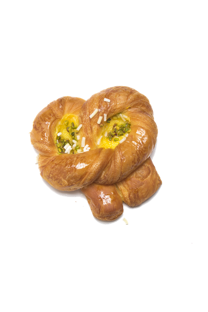 Un dolce danese dorato a forma di nodo, farcito con crema pasticcera gialla e pezzetti di pistacchio verde.