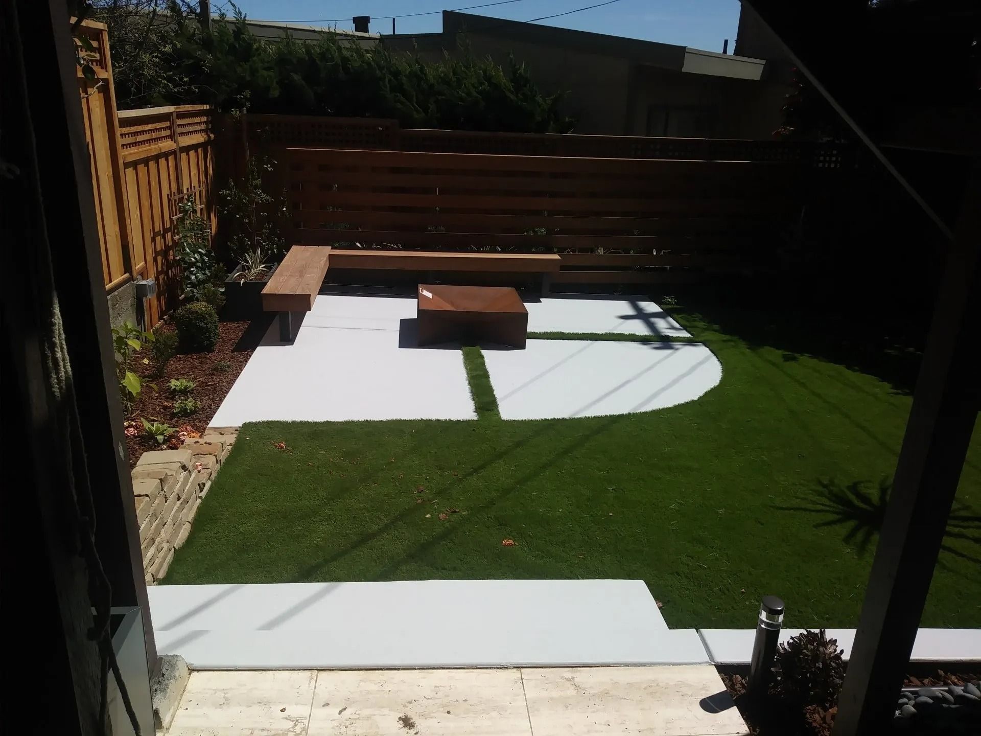A backyard with a bench and a fire pit