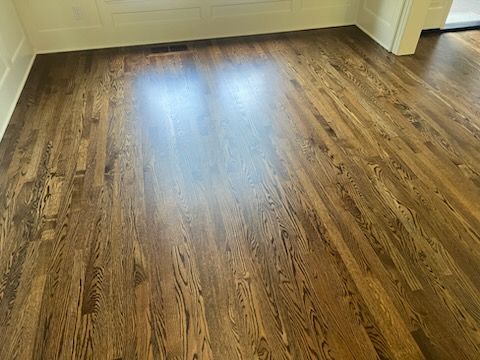 Empty room with glossy wood flooring and sunlight reflecting on the floor
