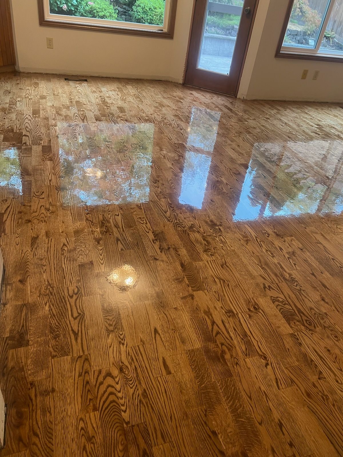 Shiny marble floor reflecting windows and doorway in an empty room