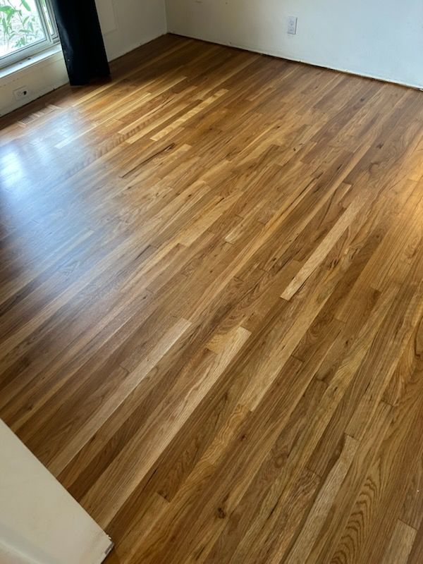 Empty room with polished wood floors and a windowed doorway
