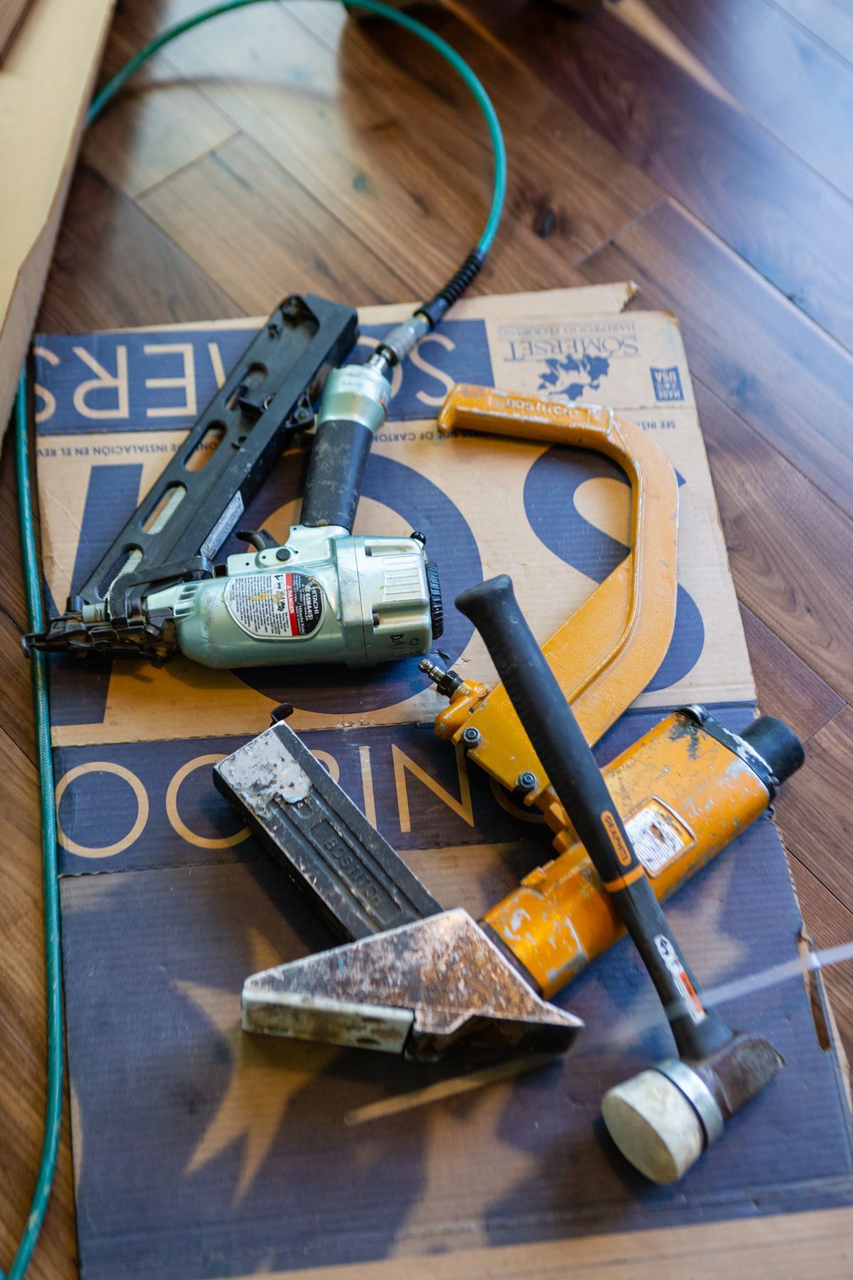 Assorted hand tools, including a tape measure, pliers, and a wrench, scattered on a wooden surface