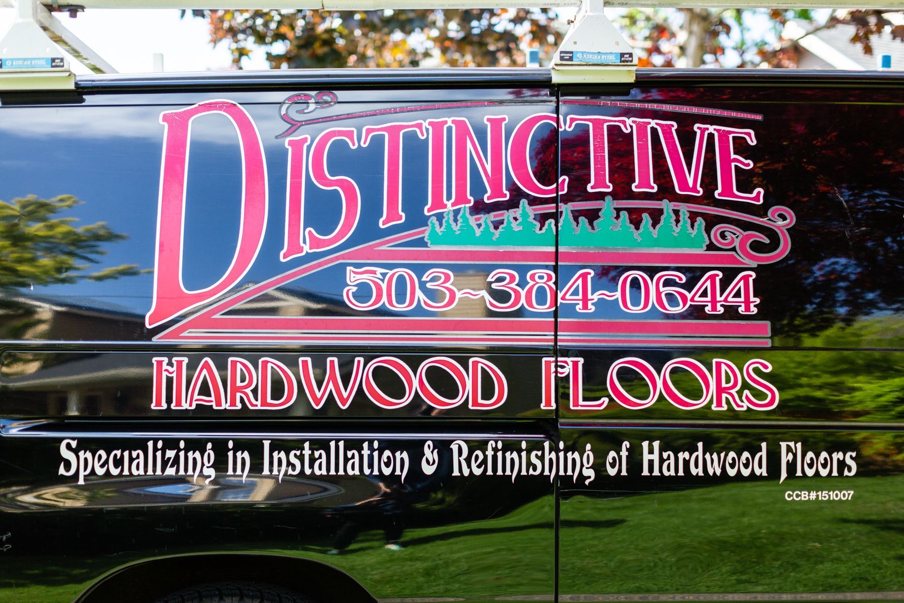 Distictive Hardwood Floors sign with phone number and “Specializing in Installation & Refinishing of Hardwood Floors”