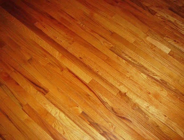 Warm-toned hardwood floor planks with a glossy finish and diagonal grain pattern