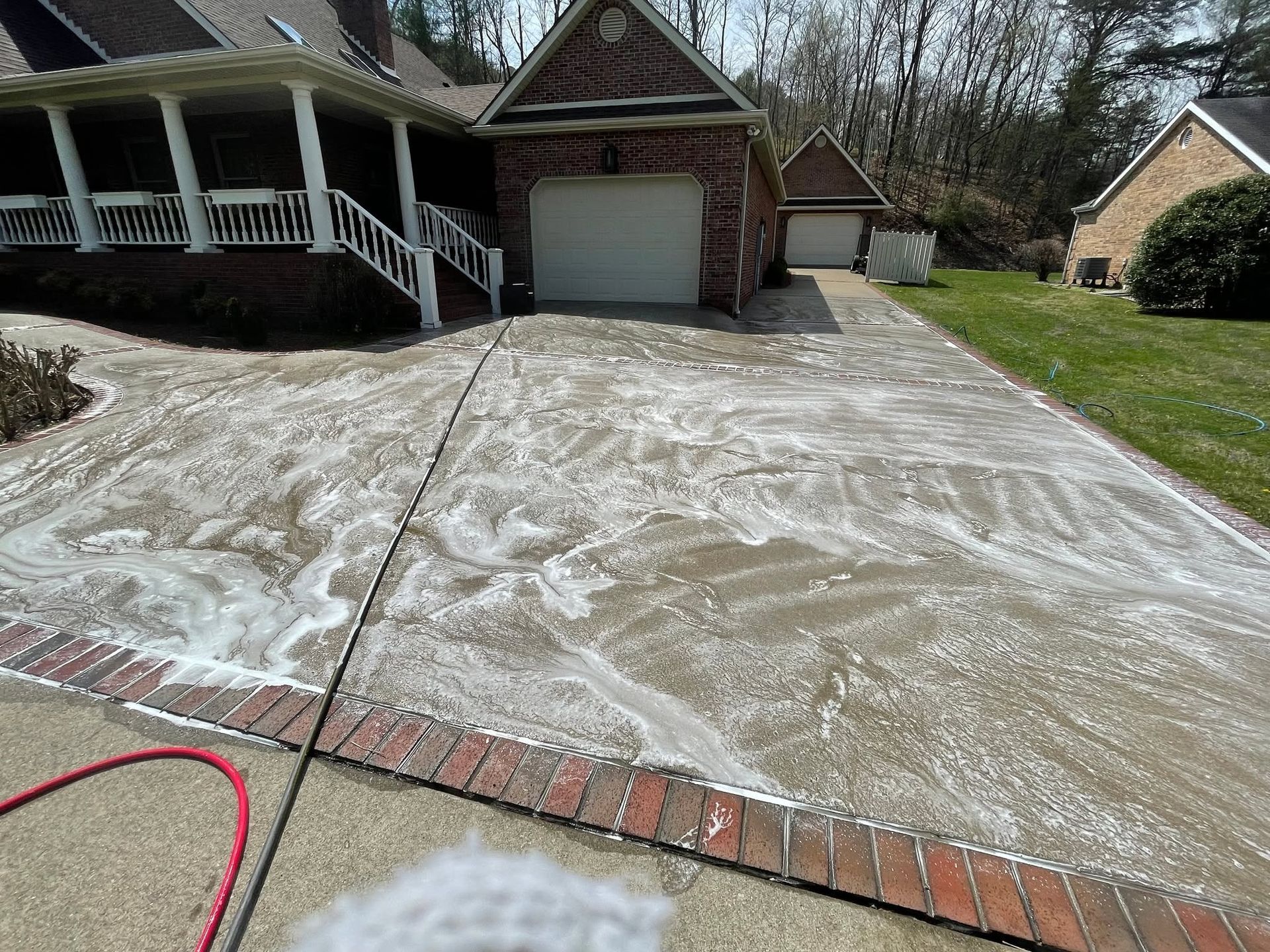 Driveway dusted with white powder in front of a house with a garage and porch