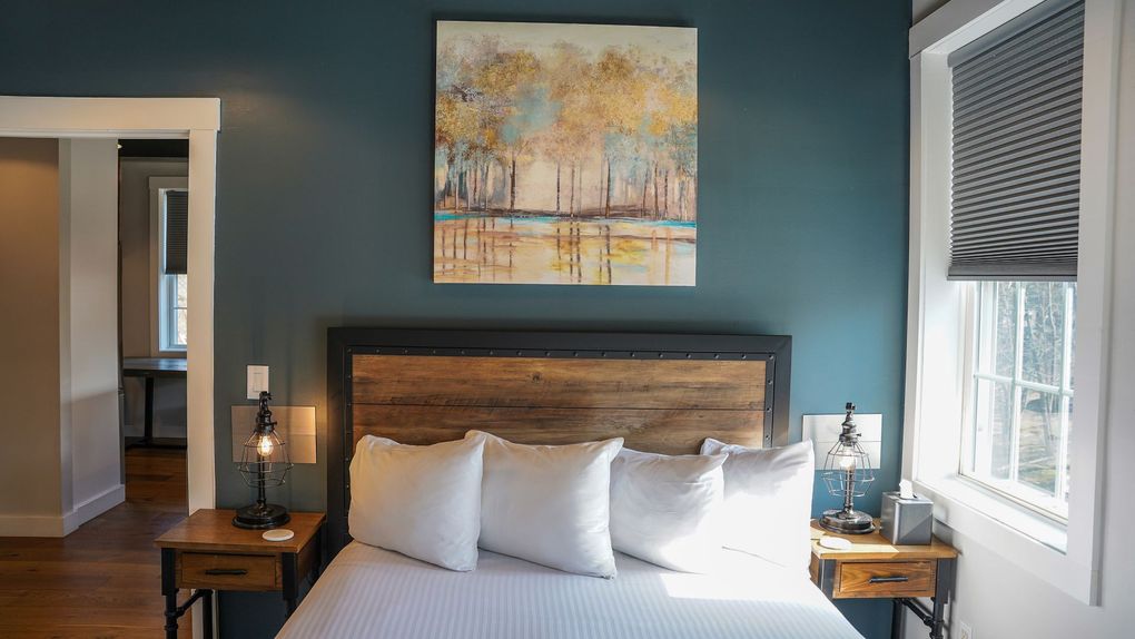 There is a painting on the wall above the bed in the bedroom.