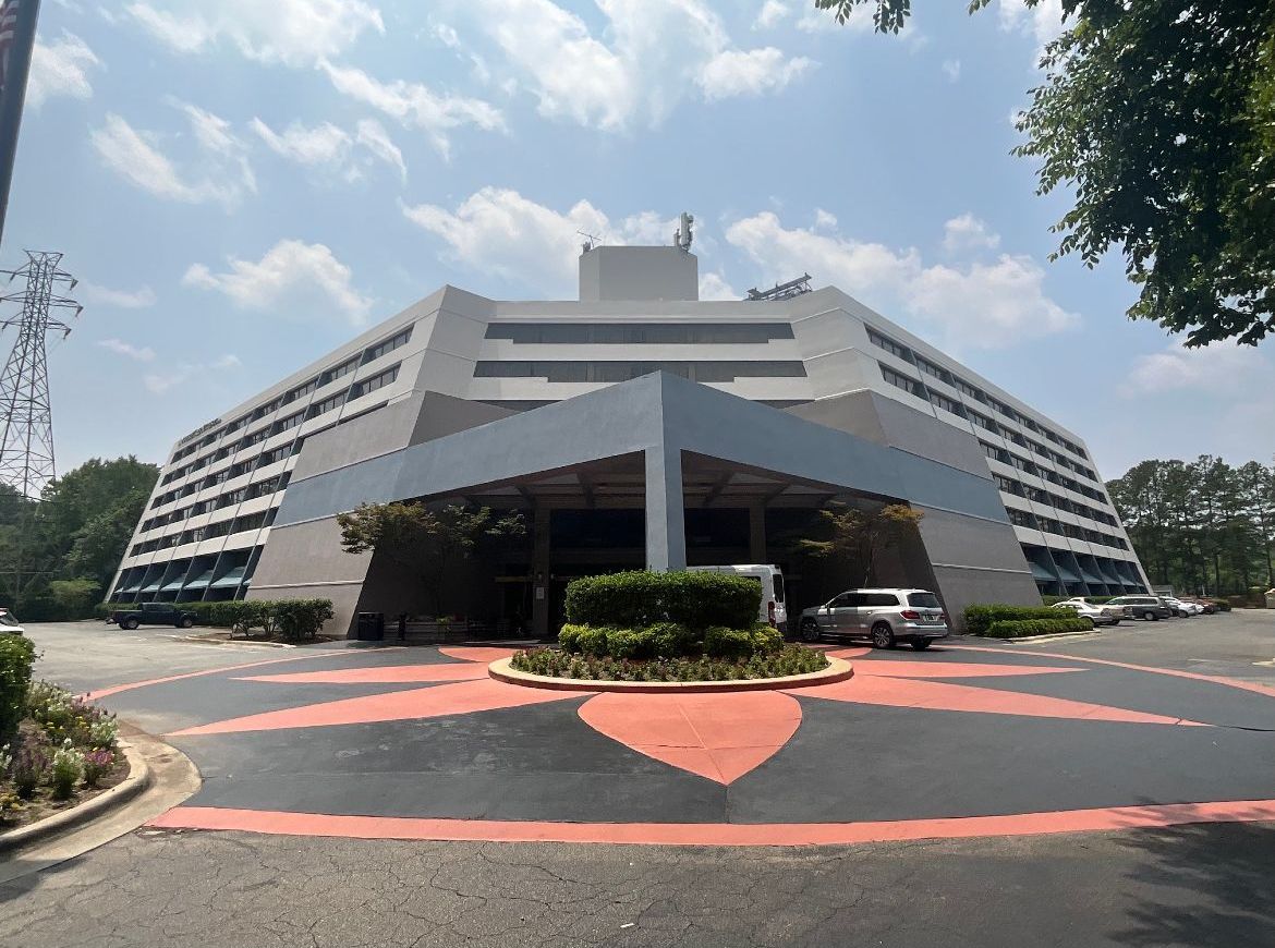 Large, angular building with gray facade. Circular driveway in front.