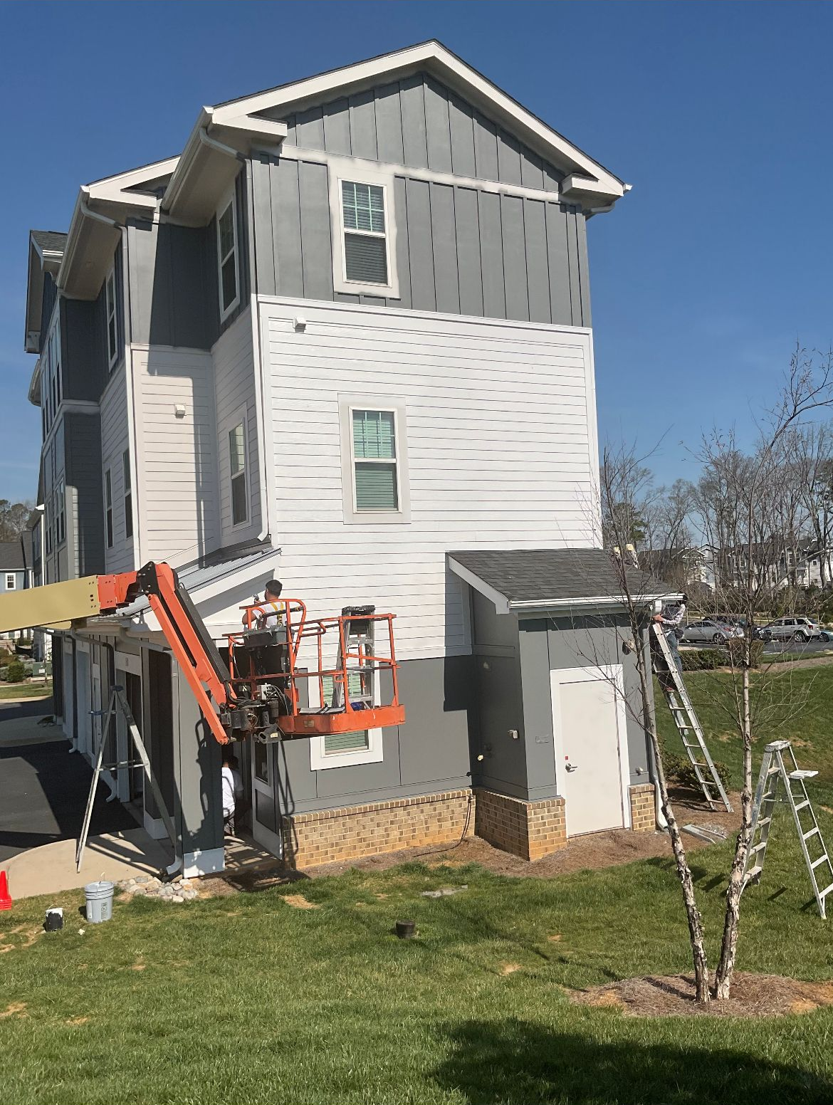Building exterior with construction; worker in lift