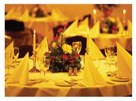 table clothes on table A table set for a dinner party with yellow napkins and candles.