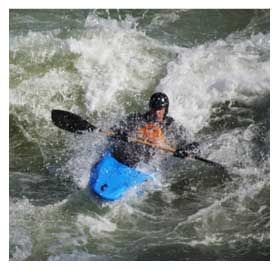 kayaker in rapids A man is paddling a blue kayak down a river.