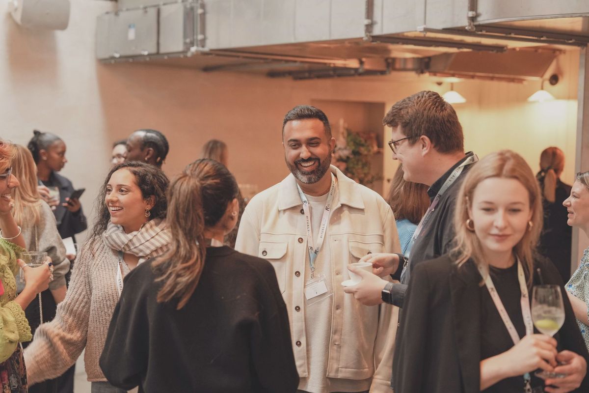 Guests mingling around a book and gifts table at a brand event, REGO Creative journal