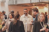 Guests mingling around a book and gifts table at a brand event, REGO Creative journal