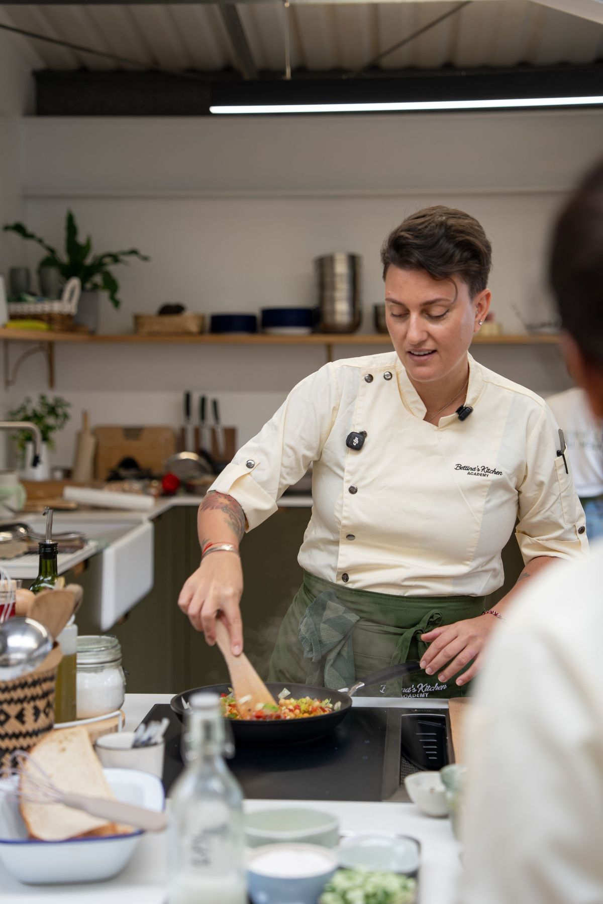 Bettina Campolucci Bordi cooking at the hob during a Retreat Chef Academy class, by REGO Creative