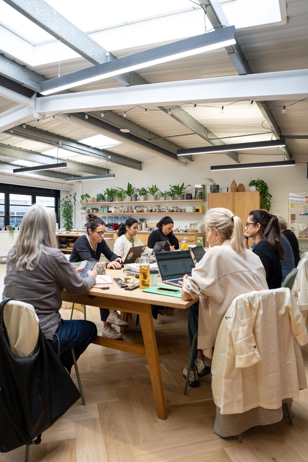 Retreat Chef Academy students working at laptops around a long table in Bettina's Kitchen Studio, by REGO Creative