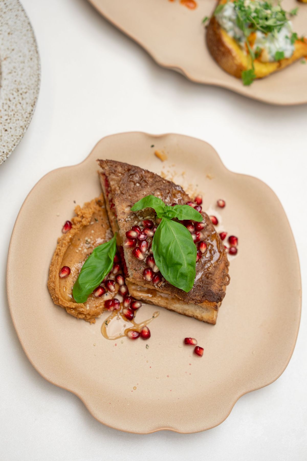 French toast with pomegranate, basil and hemp seeds on a ceramic plate, Bettina’s Kitchen by REGO Creative