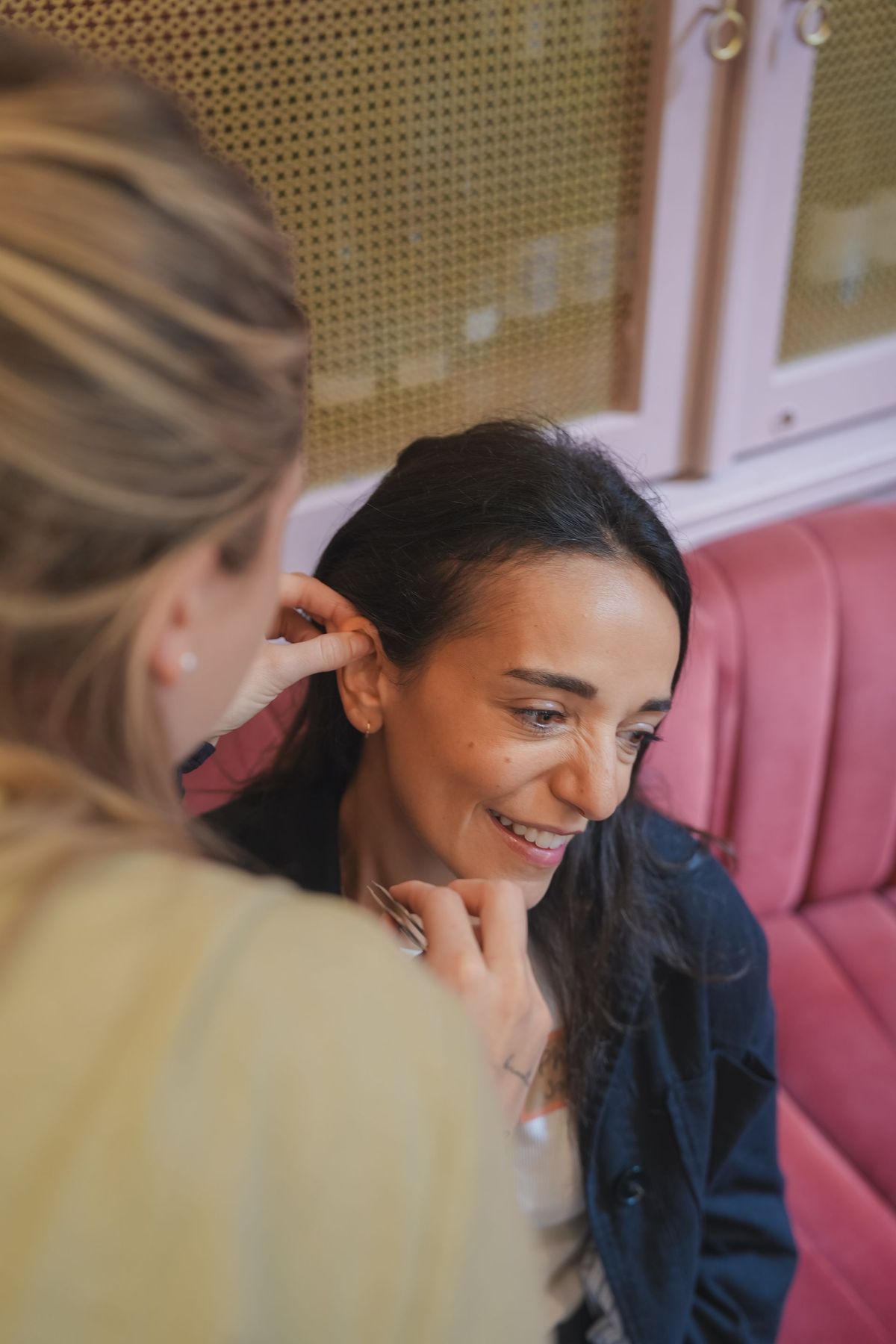 Guest smiling during a hands-on beauty treatment at the Coral Press launch event, by REGO Creative