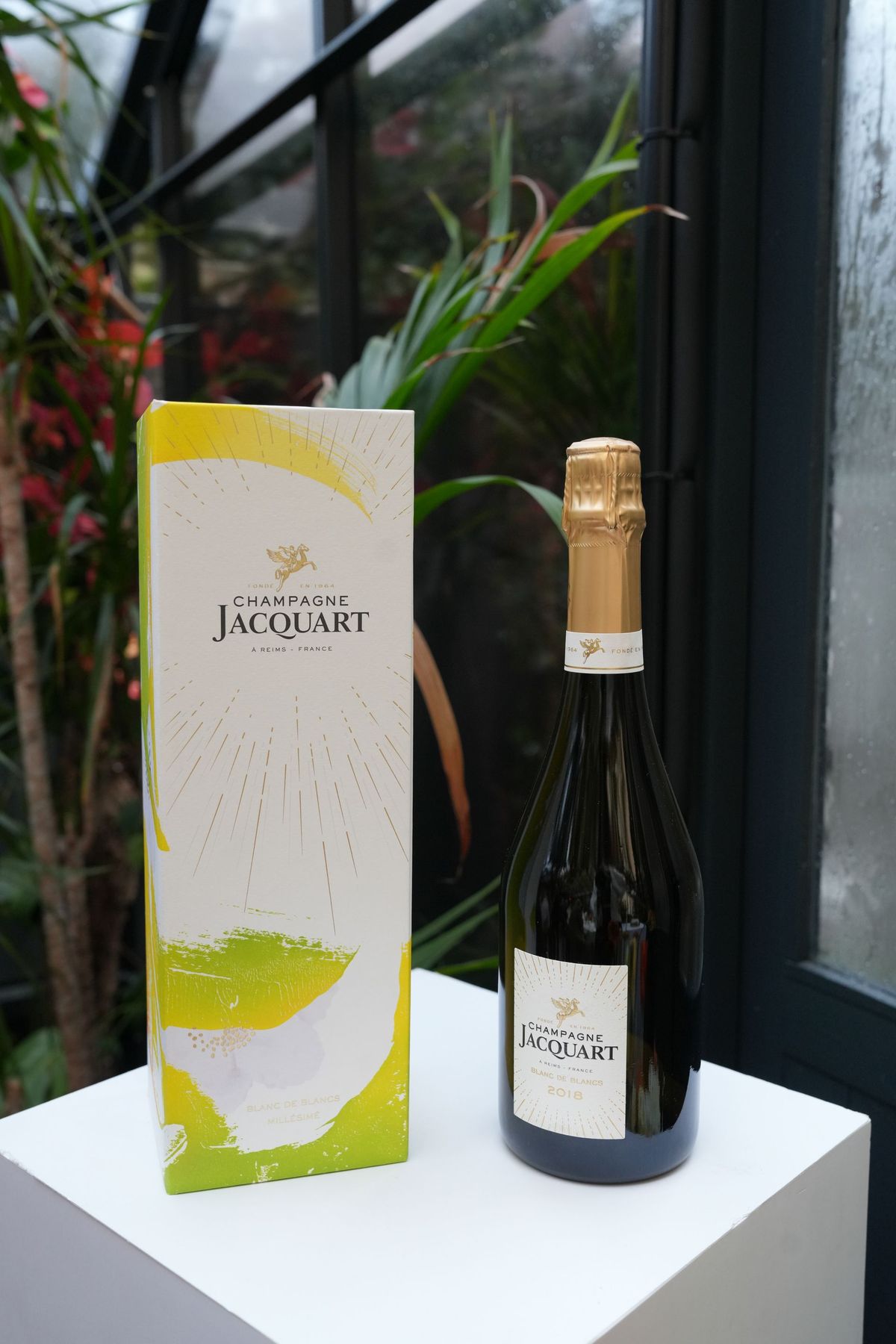 Champagne Jacquart Blanc de Blancs bottle and gift box on a white plinth, by REGO Creative