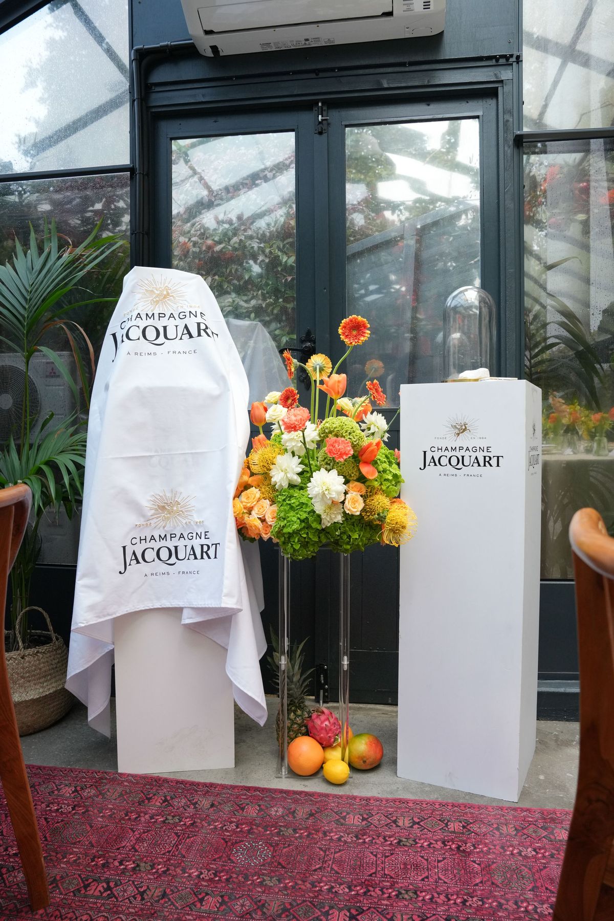 Champagne Jacquart branded entrance with flowers and a display plinth at the launch dinner, by REGO Creative
