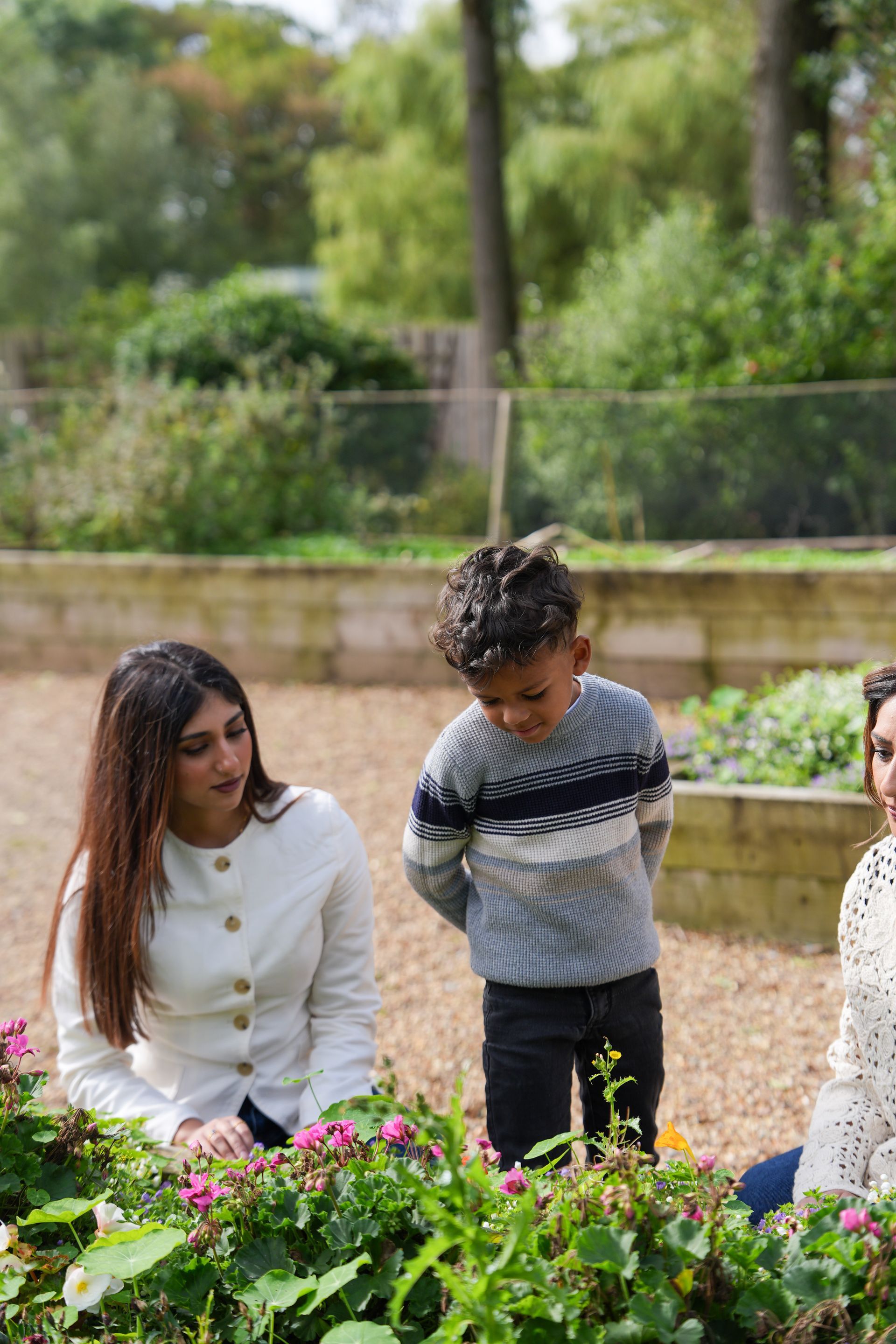 Young woman and a small boy looking at flowers together in a garden, Lancashire County Council by REGO Creative