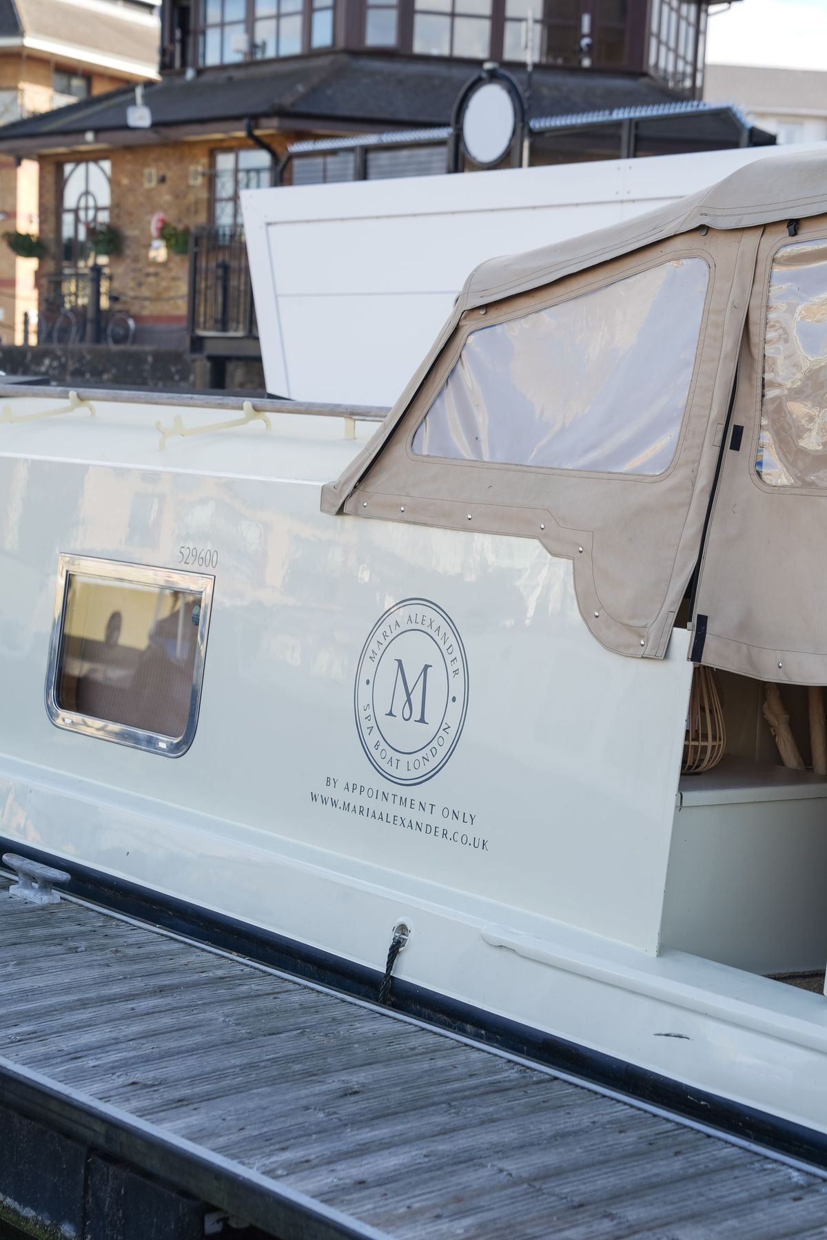 Maria Alexander Spa Boat moored in Limehouse Basin with its logo on the hull, by REGO Creative