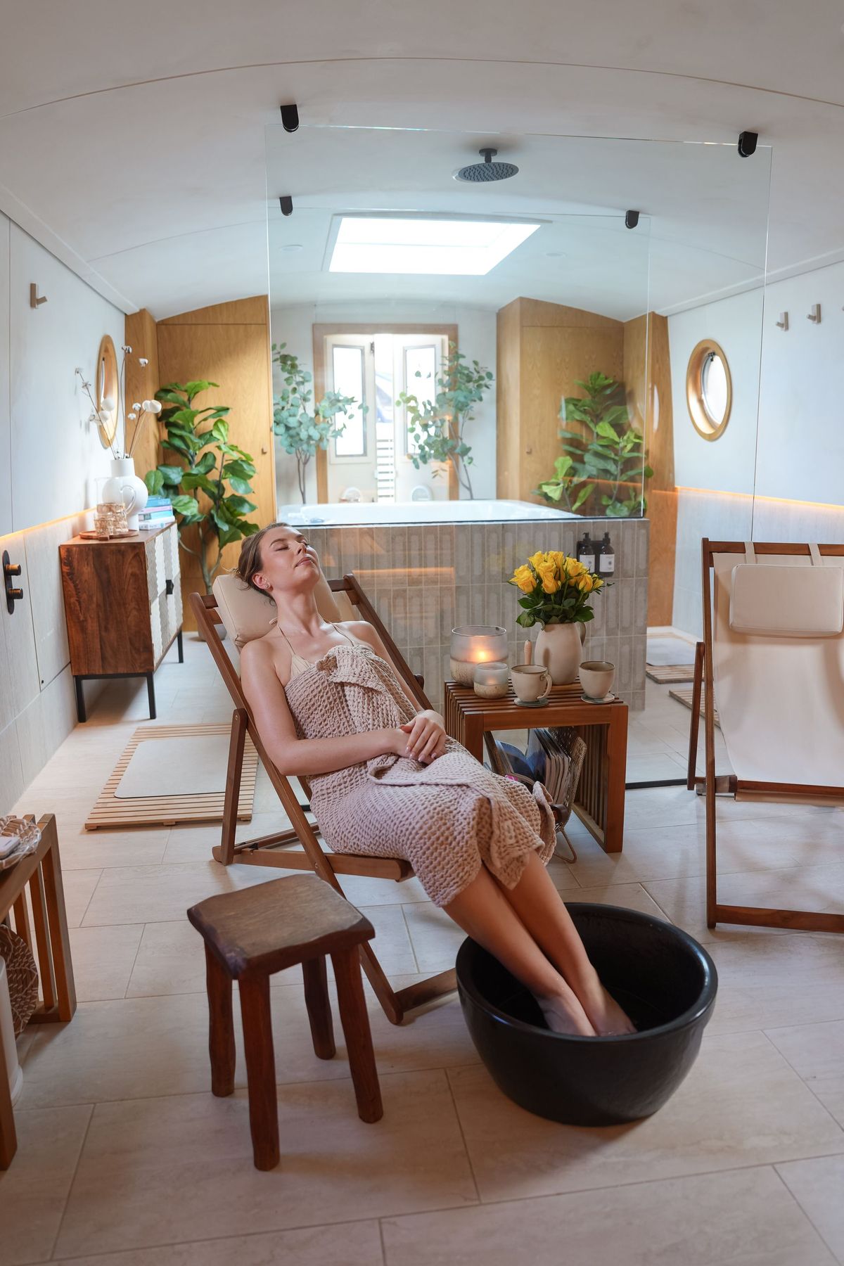 Guest relaxing with a footbath inside the Maria Alexander Spa Boat in London, by REGO Creative