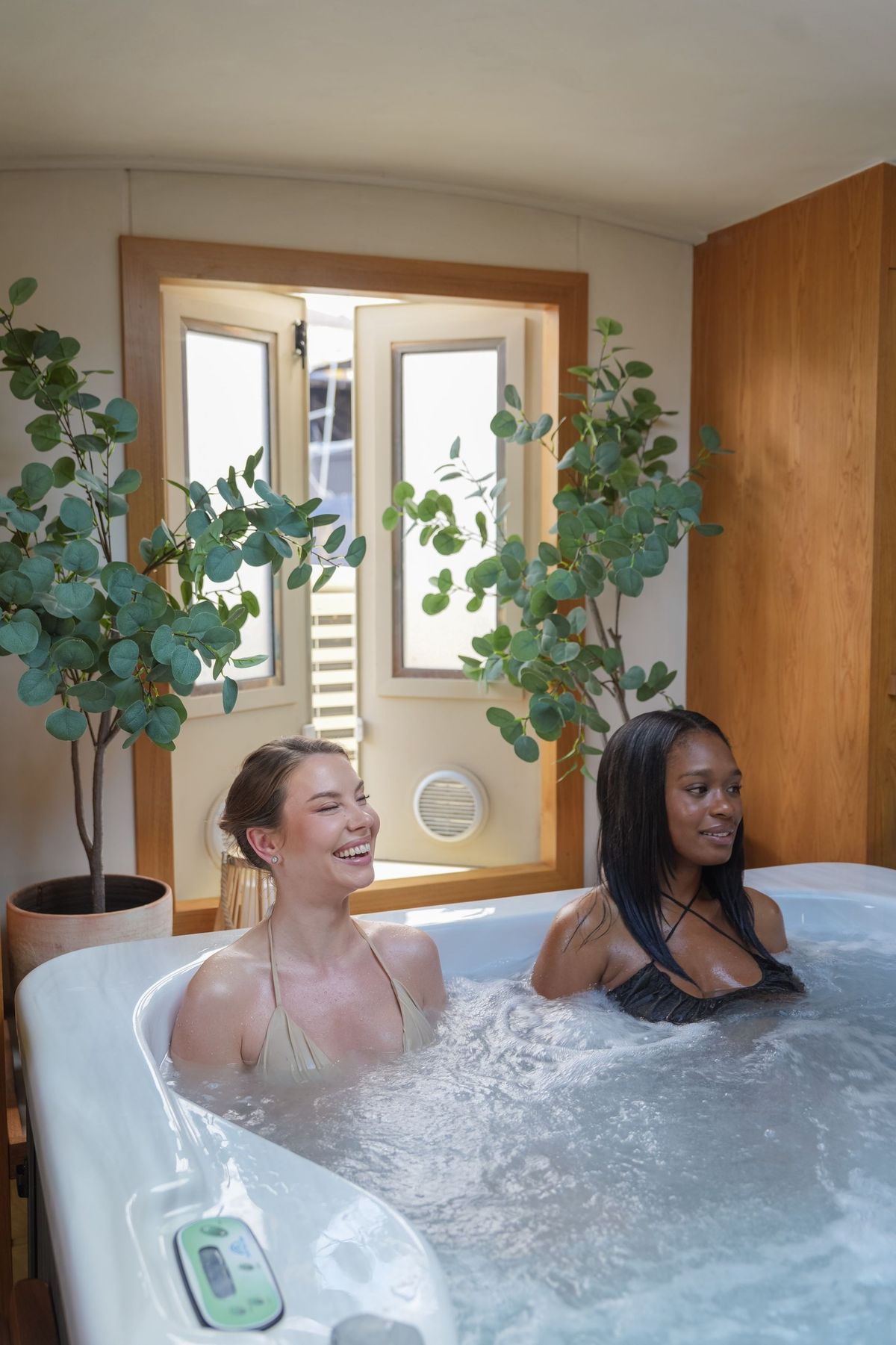 Two guests laughing in the hot tub aboard the Maria Alexander Spa Boat, by REGO Creative
