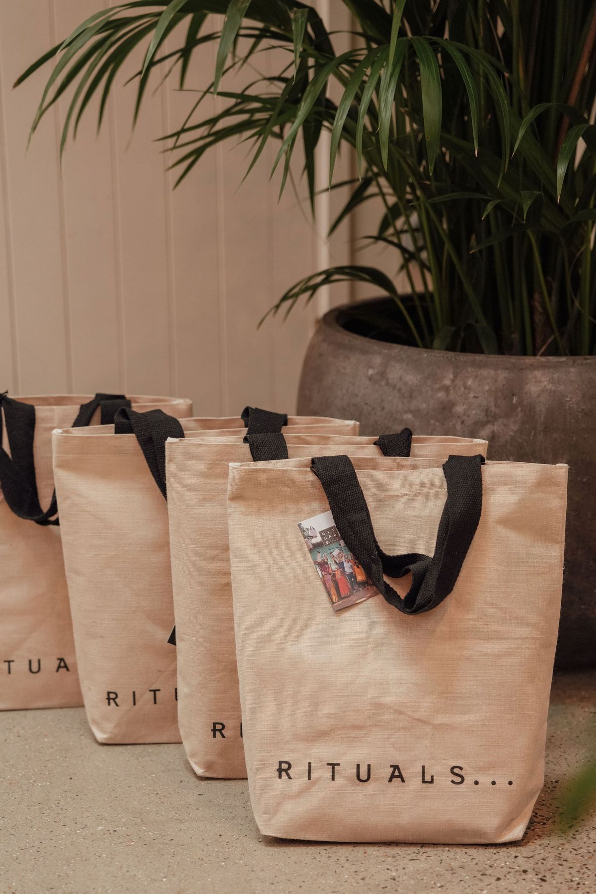Rituals gift bags beside a palm at The Rider Reset event, Penguin Random House by REGO Creative