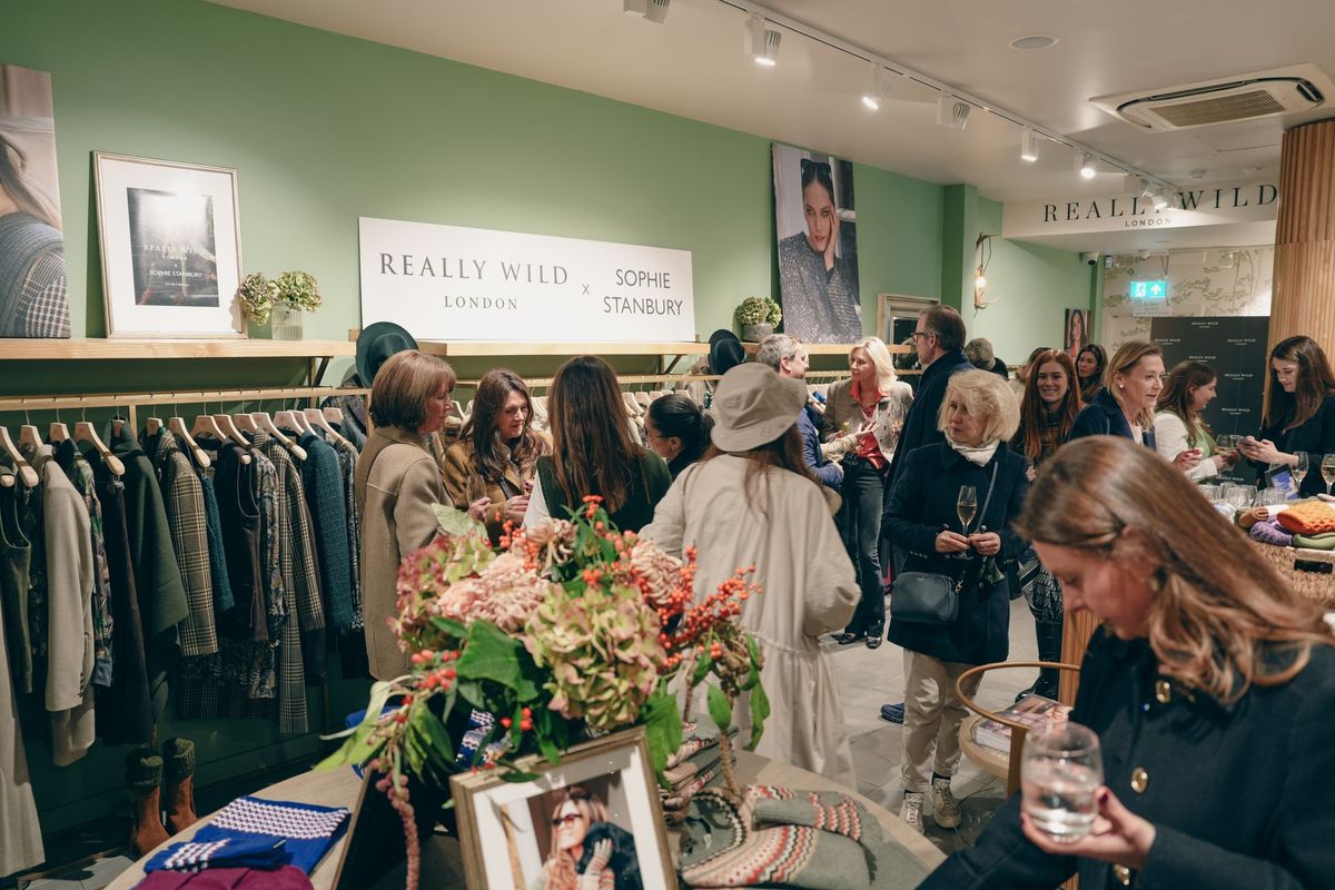 Guests mingling in the Really Wild London Sloane Square shop beneath the Really Wild x Sophie Stanbury sign, by REGO Creative